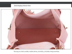 Pink synthetic leather bag detail showing spacious interior and golden base rivets