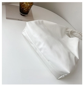 Detail view of the flat bottom structure of this white minimalist faux leather tote bag