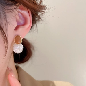 Detailed close-up of French vintage amber and marble resin earrings worn by a model