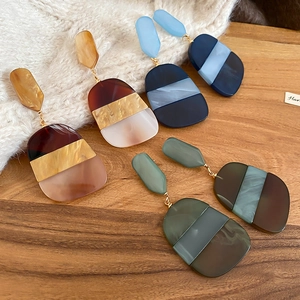Detailed macro view of geometric acetate drop earrings in various marbled color patterns