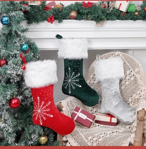 Detailed view of red, green, and silver velvet Christmas stockings with snowflake embroidery