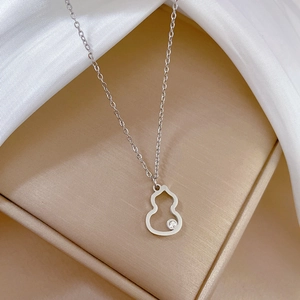 Macro detail of silver hollow gourd pendant with a sparkling diamond on a delicate chain