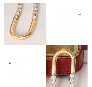 Macro detail of U-shaped surgical steel earrings with 18k gold plating and zircons