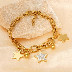 Detail of 18k gold plated double chain bracelet with crystal star charms on stone decor
