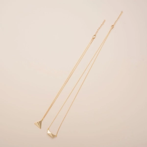 Minimalist gold layered necklace featuring origami airplane and boat geometric pendants