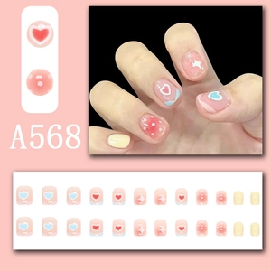 Detail of sweet press-on nail kit with rainbow hearts, polka dots and yellow accents
