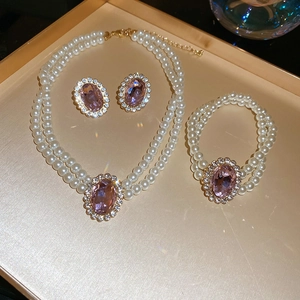 Close-up of pink crystal oval pendant necklace set with pearls and pavé diamonds
