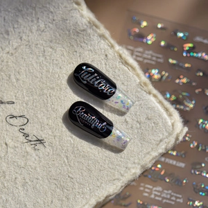 Nails art noirs laser modernes avec lettrage iridescent et dégradé pailleté coloré