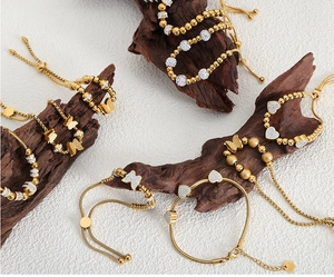 Close-up of gold-plated bracelets featuring butterfly charms and pave-set zircons