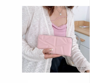 Detail of pink PU leather long wallet with geometric stitching held by a lady