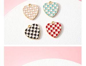 Detail of four checkered enamel heart charms in pink blue black and red for DIY jewelry