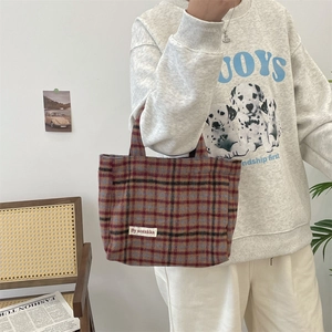 Detail of vintage plaid tote bag featuring woven By sozakka label and thick fabric texture