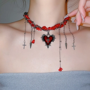 Nahaufnahme eines Gothic-Chokers mit roten Schmucksteinen und Herz-Kreuz-Anhängern