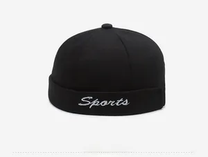 Detail of black cotton docker cap featuring white Sports cursive letter embroidery