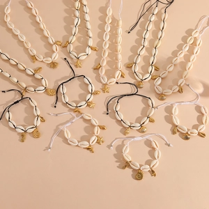 Flat lay detail of natural shell necklaces and bracelets with gold sea creature charms