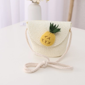 Détail d'un mini sac en paille pour enfants avec une décoration d'ananas mignonne