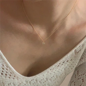 Close-up of minimalist gold zircon pendant necklace worn on neck for delicate style