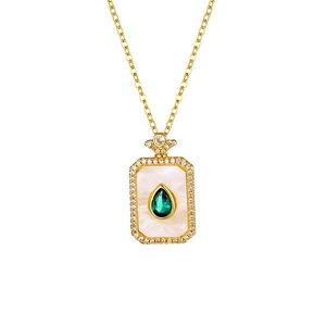 Macro detail of rectangle gold necklace featuring pear-cut emerald and sparkling zircon accents