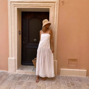 Elegant white pleated maxi dress with square neck and spaghetti straps on a model