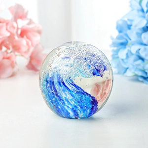 Boule de cristal presse-papier en verre vague, sphère transparente avec vague bleue et bulles.