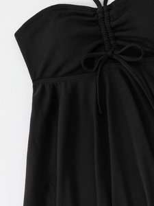 Close-up of black ribbed bikini top featuring drawstring ruched center and bow tie detail