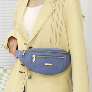 Detailed shot of a blue PU sports waist bag with gold zippers worn on a yellow suit