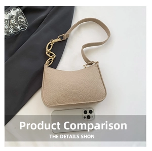 Detail of beige faux crocodile leather bag featuring a chunky gold chain strap and smooth texture