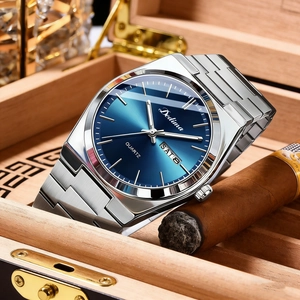 Macro shot of a silver steel watch with a blue sunray dial inside a luxury wooden cigar box