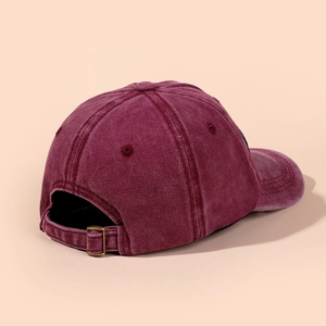 Close-up of vintage washed burgundy baseball cap showing metal buckle and stitching