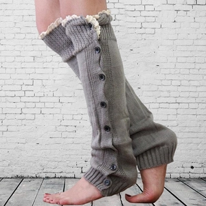 Detail showing grey knit leg warmers with black buttons and white lace trim edge