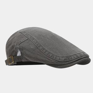 Gros plan sur un béret en coton gris avec boucle latérale en laiton vieilli et texture