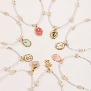 Collana di perle bohémien con ciondoli floreali in smalto dorato in vari stili