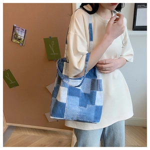 Detail of the blue denim patchwork tote bag showing fabric texture and shoulder strap