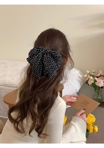 Detailed back view of a large French vintage polka dot chiffon bow hair clip on model