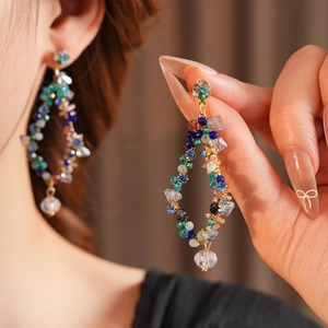Macro shot of vintage gold earrings with colorful beads and diamond fringe detail