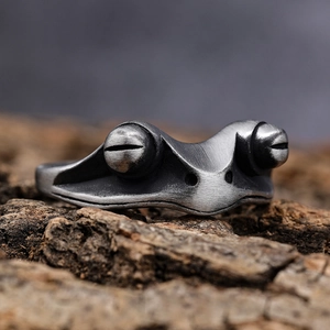 Gothic vintage frog ring in oxidized stainless steel on rustic wood bark background