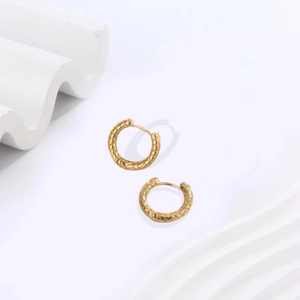 Detail of 18K gold-plated U-shaped earrings with intricate twisted rope texture pattern