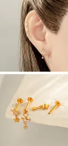 Detail of gold titanium cartilage studs with zirconia stars and flower charms