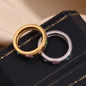 Detail of gold and silver rectangle rings with colorful zircons on a blue gift box
