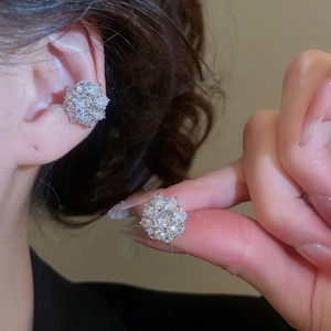 Detail view of sparkling zircon flower ear cuffs worn to show size and luxury finish