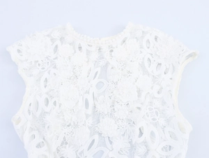 Détail de robe en dentelle blanche avec broderie florale et encolure ajourée chic