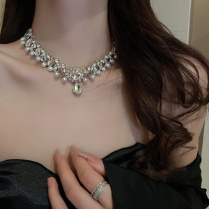 Detail of French floral pearl necklace with water drop pendant and pavé diamond rings