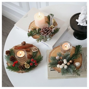 Macro detail of Christmas log candle holder with pine cones berries and gold bell