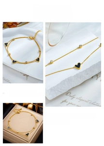 Detail of gold-plated double-layer anklet with black heart charms and round zircons