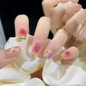 Detail von rosa Press-on-Nägeln mit handgemalten Blumen und funkelnden 3D-Kristallen