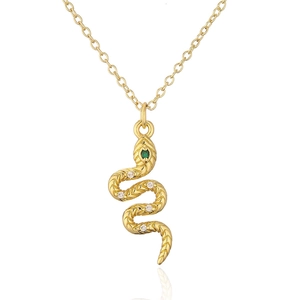 Macro shot of 18K gold snake pendant with green gem eyes and sparkling zircons