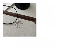 Detailed view of S925 sterling silver bow pendant with black adjustable cord necklace