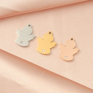 Three mirror-polished angel pendants in gold, silver, and rose gold on pink silk