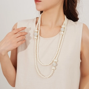 Close-up of double-layered pearl necklace with rhinestone-encrusted balls on model