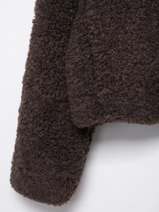 Close-up detail of dark brown teddy fleece fabric on thick winter jacket